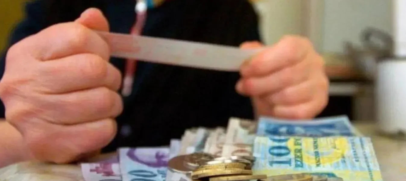 Nyugdíjas a kézben tartott csekken nézi, mennyi pénz jár neki