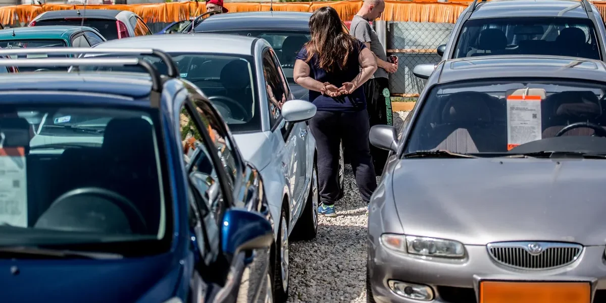 Régebbi személyautók parkolnak egy autókereskedésben.