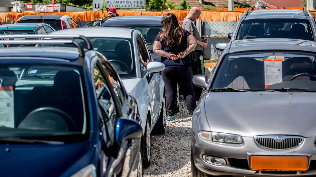 Régebbi személyautók parkolnak egy autókereskedésben.